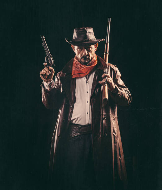 Hungarian outlaw man in black mask pointing shotgun in sunset, selective focus