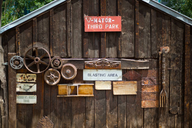 Old historic log cabin and antique rusted plow in the American Midwest.