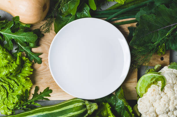 istock Vegetables frame with white ceramic plate in the centre of composition 817544314