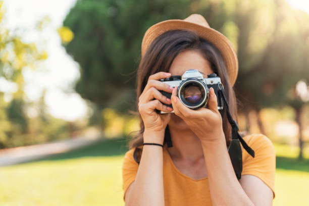 istock Young woman using a camera to take photo. 817544532