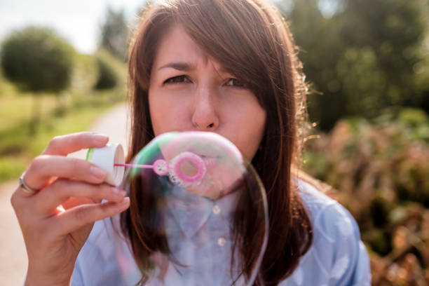 istock Girl blowing bubbles outdoor. Focus on lips. 817544980