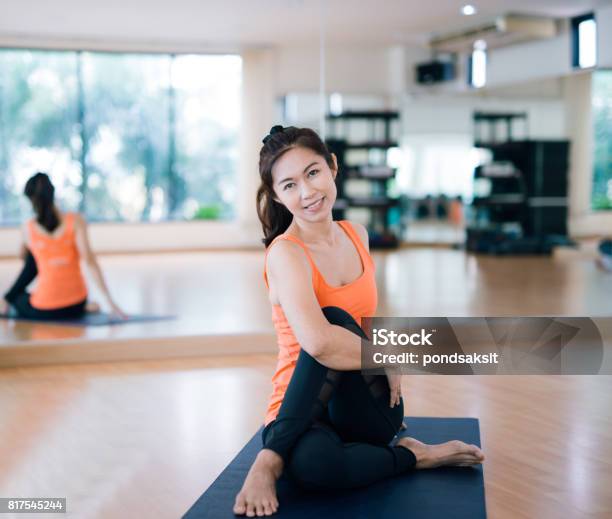 Yoga Fitness Sport Training And Lifestyle Concept Smiling Woman Stretching Leg On Mat In Gym Stock Photo - Download Image Now