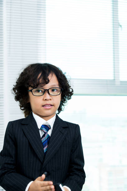 istock Boy dressed in business suit standing 817545498