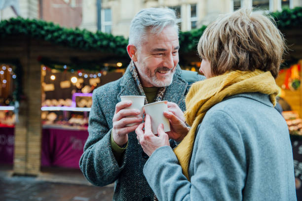 istock Elderly Couple Drinking Hot Drinks at Christmas Market 817551836