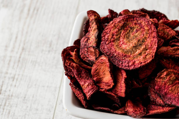 istock Purple Baked Beet Chips on white wooden surface. 817553758