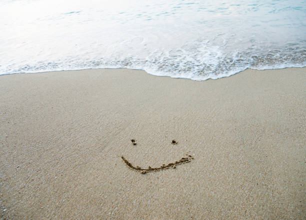 Single smile face on the sand of a beach