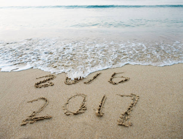 istock Digits 2017 and 2016 on the sand of a beach 817571118