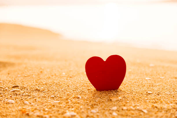 istock Red heart shape on the golden beach 817571124