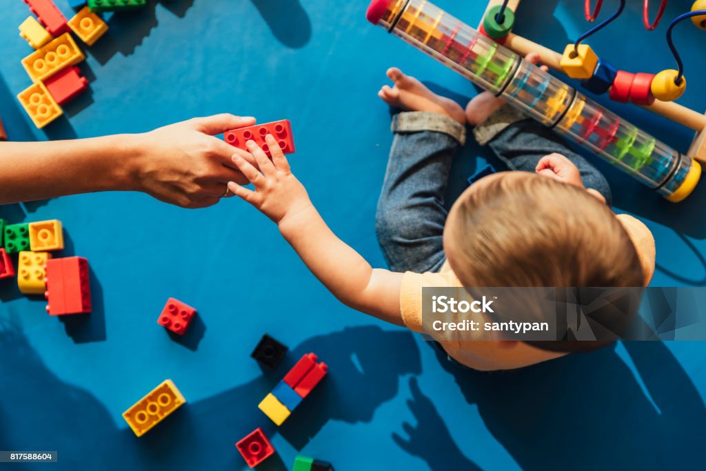 Happy baby playing with toy blocks. Happy baby playing with toy blocks in the kindergarten. Preschool Stock Photo