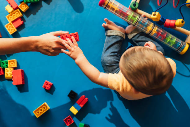 Happy baby playing with toy blocks. Happy baby playing with toy blocks in the kindergarten. child care photos stock pictures, royalty-free photos & images