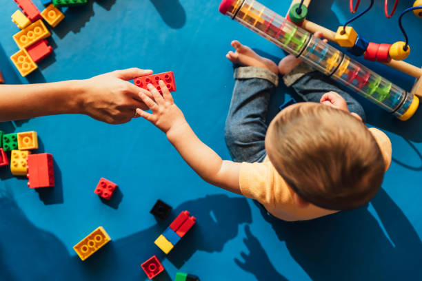 Happy baby playing with toy blocks. Happy baby playing with toy blocks in the kindergarten. child care stock pictures, royalty-free photos & images