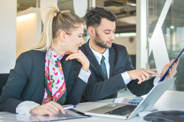 istock Business people in formal wear discussing paperwork in office. 817601704