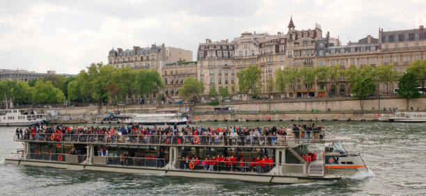 Paris,France- April 29, 2017: On the river Seine sailing ship with cheerful tourists