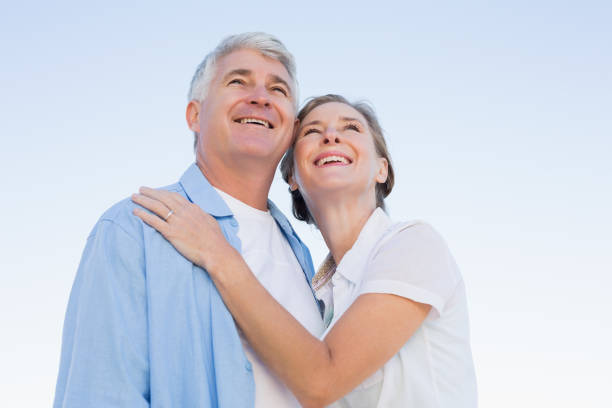 istock Happy casual couple embracing under blue sky 817648258