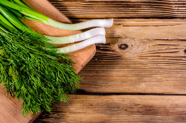 istock Green dill and onion on cutting board. Top view 817696660