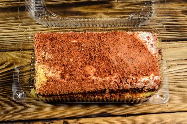 istock Biscuit cake in plastic container on wooden table. Top view 817697886