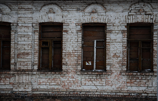 Old wall and windows of the abandoned building