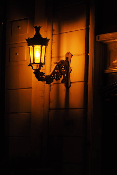 istock Old red bricks wall and light hanging on the wall. Night 817703082