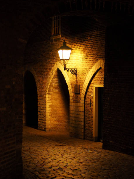 istock Old red bricks wall and light hanging on the wall. Night. Arch. fortress 817703350