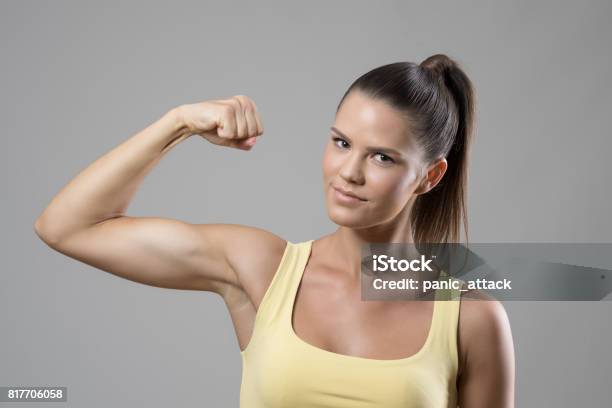 Young Fit Sporty Woman In Singlet With Ponytail Flexing Biceps Arm Muscle  Looking At Camera Stock Photo - Download Image Now - iStock