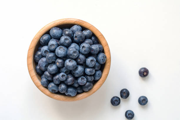 Blueberries in wooden bowl on white
