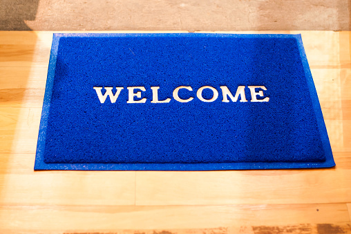 Welcome Mat Inside Door, Blue color On wooden floor