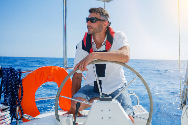 istock Young man sailing yacht 817745872