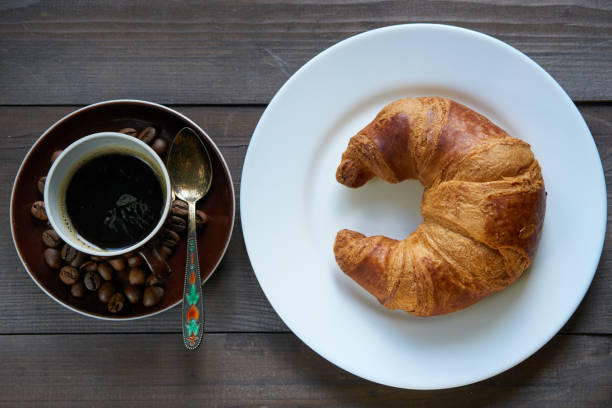 istock light morning breakfast. croissant and cup of coffee espresso 817746112
