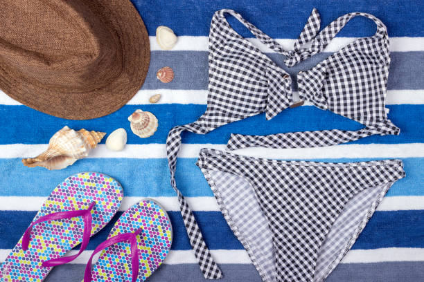 istock Summer background with straw hat, flip flops and swimsuit. Top view 817773594