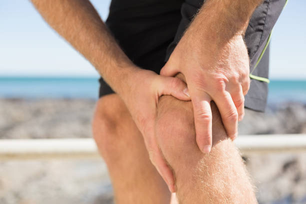 istock Fit man gripping his injured knee 817780512