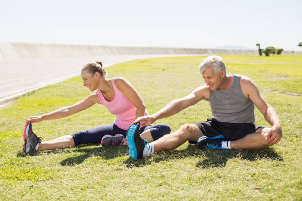 istock Fit mature couple warming up on the grass 817789702