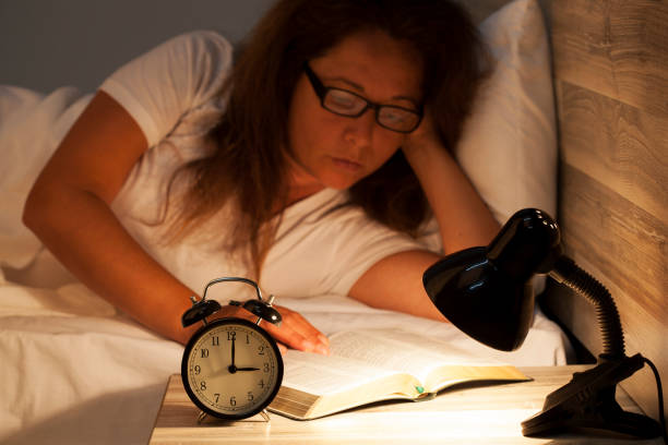 istock Woman lying in bed and reading  a book 817798568