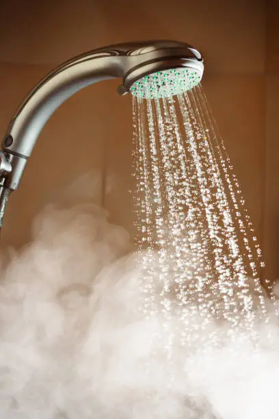 shower with flowing water and steam, closeup view