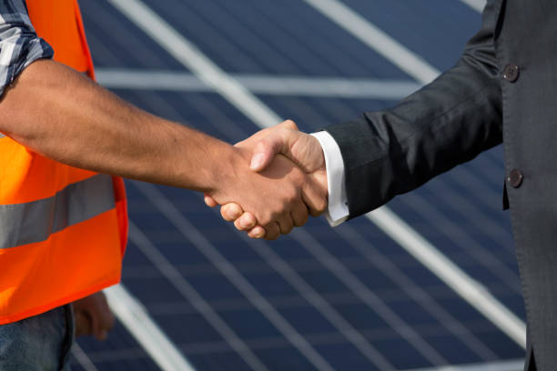 istock Foreman and businessman shaking hands at solar energy station. 817823150