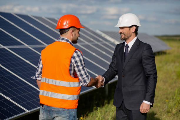 istock Businessman and foreman shaking hands at solar energy station. 817823596