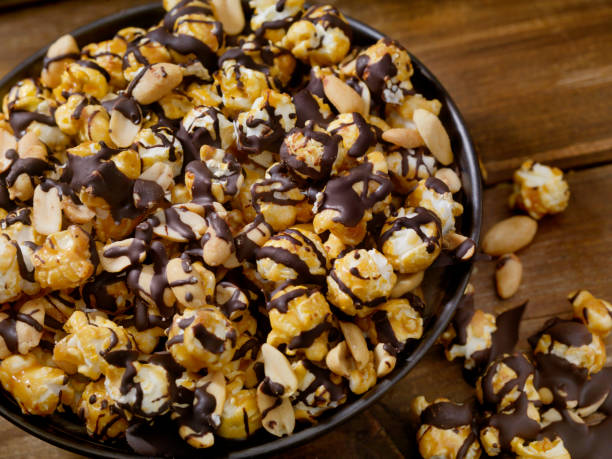 czekoladowy karmelowy popcorn z orzeszkami ziemnymi - popcorn snack bowl corn zdjęcia i obrazy z banku zdjęć