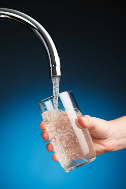 istock hand pouring a glass of water from filter tap 817832020