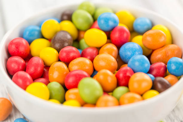Cocolate coated Peanuts on an old wooden table as detailed close-up shot (selective focus)