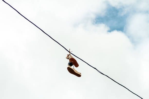 9th Street, Long Island City, Queens, New York, USA – May 10, 2018: Bunch of shoes hanging from a electric wire
