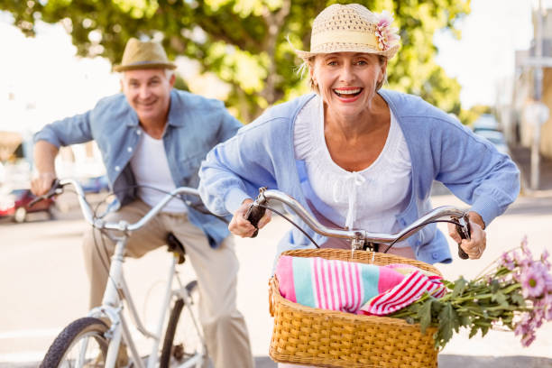 都市の自転車のために行く幸せな熟年カップルに乗る - retirement mature couple couple bicycle ストックフォトと画像