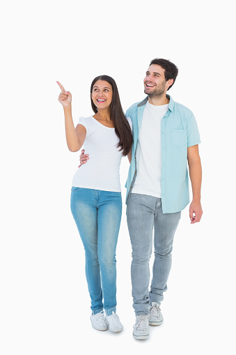Happy casual couple walking together on white background