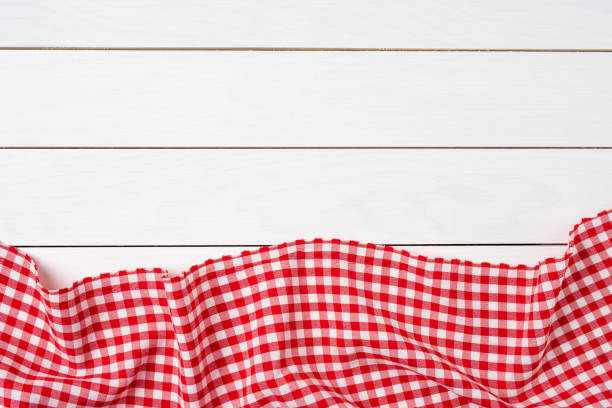 istock Red checkered tablecloth over white wooden table 817860194