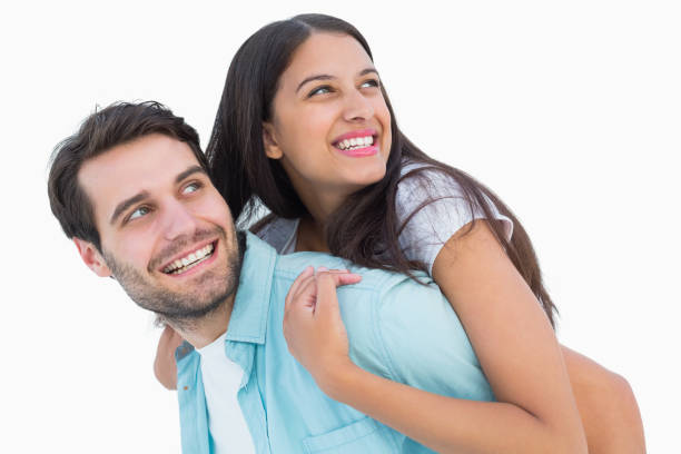 istock Happy casual man giving pretty girlfriend piggy back 817860294