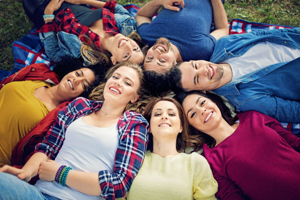istock Happy friends are lying down on the grass in the park 817932910