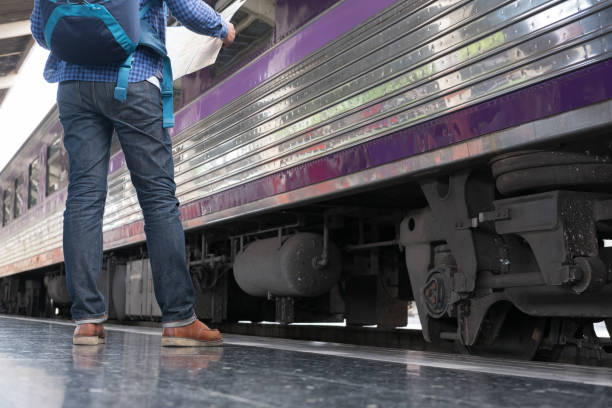 istock asian man with backpack standing on platform at train station. backpacker or traveler waiting for train. journey, trip, travel concept 817933074