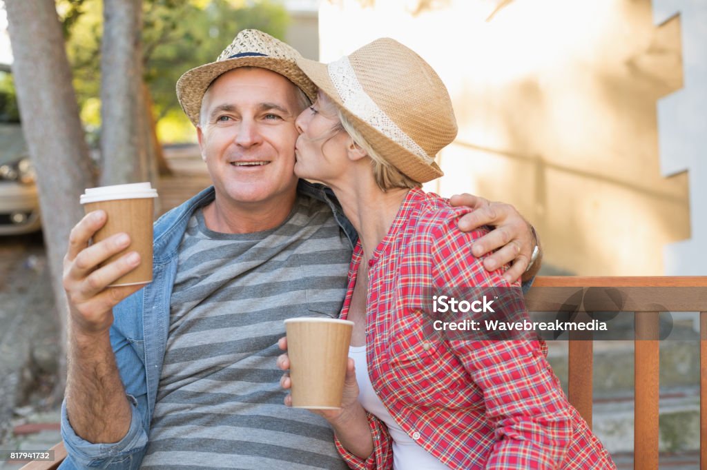 Feliz pareja madura bebiendo café en un banco en la ciudad - Foto de stock de Café - Bebida libre de derechos