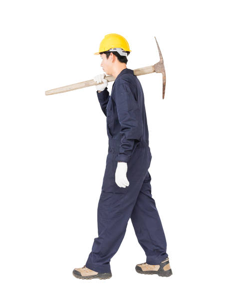 Man in uniform hold old pick mattock that is a mining device