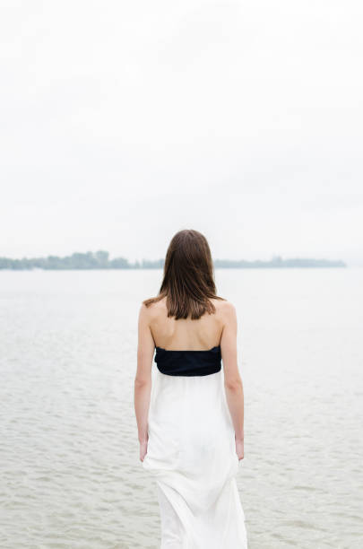 back view of lonely girl, young woman walking surrounded by the water and relief stress and depresion, space for text on white background