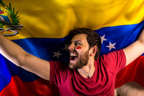 istock Venezuelan fan holding the national flag 817999020