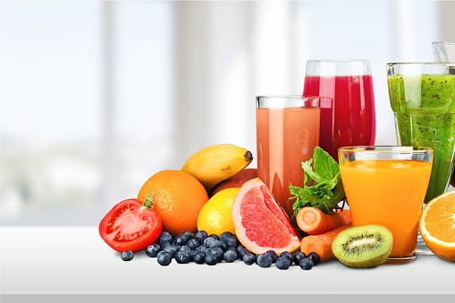 Various glasses of juice and fruits